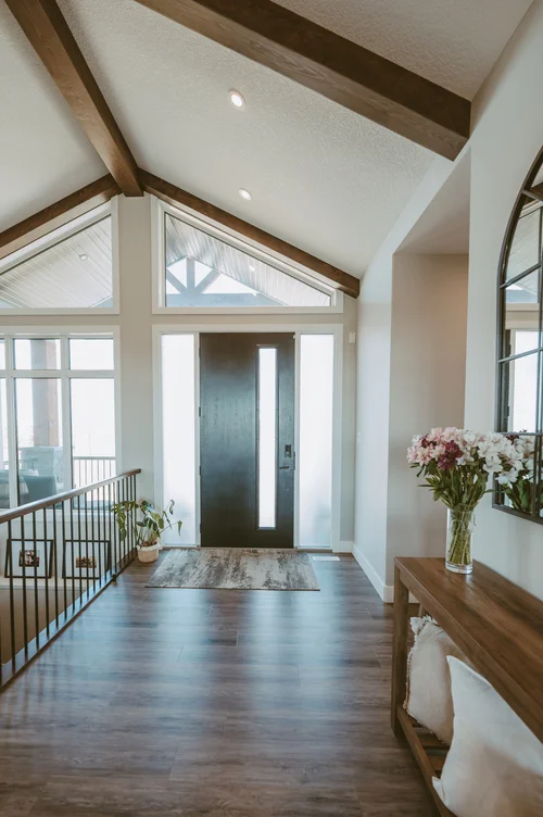 Entry foyer with vaulted ceiling and black door