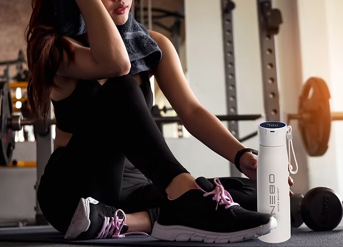 Female athlete in gym with the ONE80 Revolution water bottle