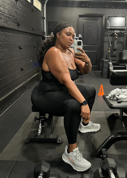 Lizzo smiling and taking a post-workout selfie, showcasing her fitness progress