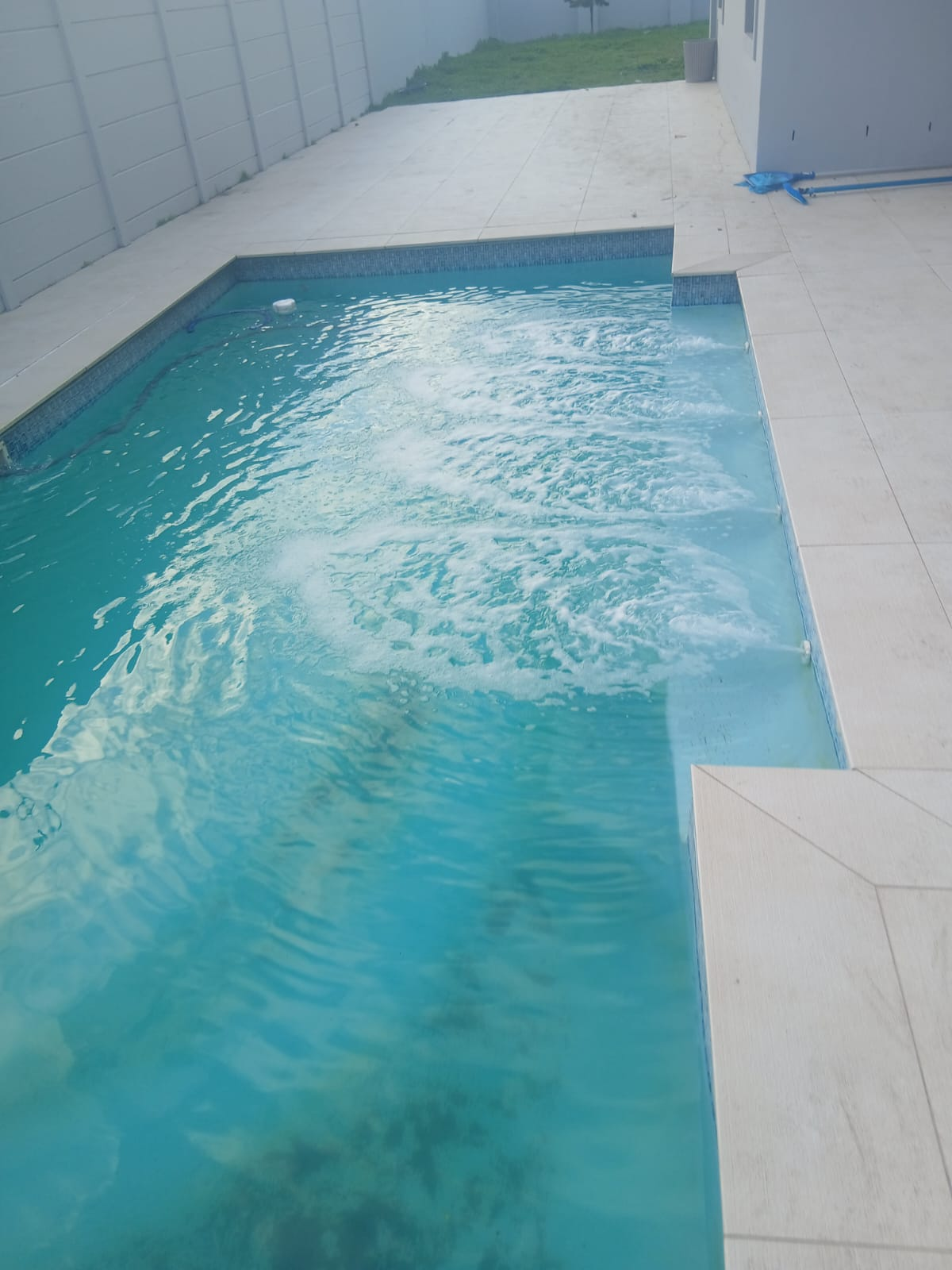 Blue swimming pool with paved surround