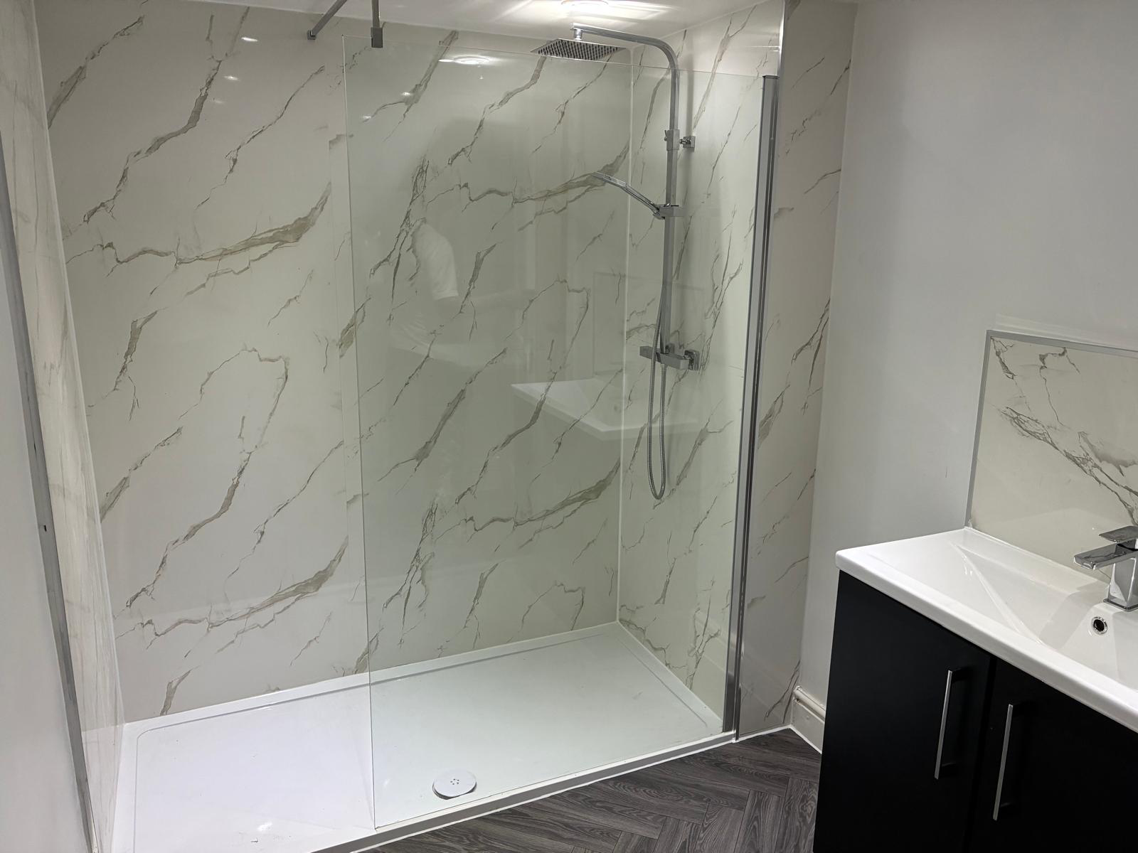 Modern white marble shower enclosure with floor heating