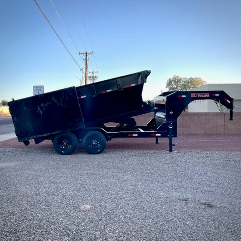 Roll-off dumpster trailer with bed tilted in dump position, side view