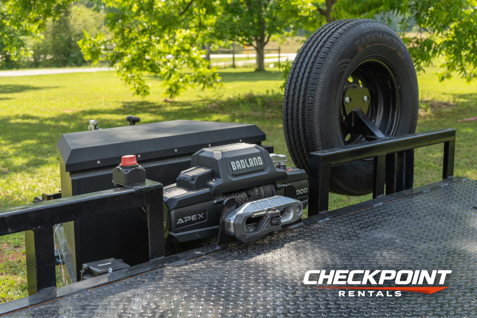 Badland winch and spare tire mounted at front of car hauler