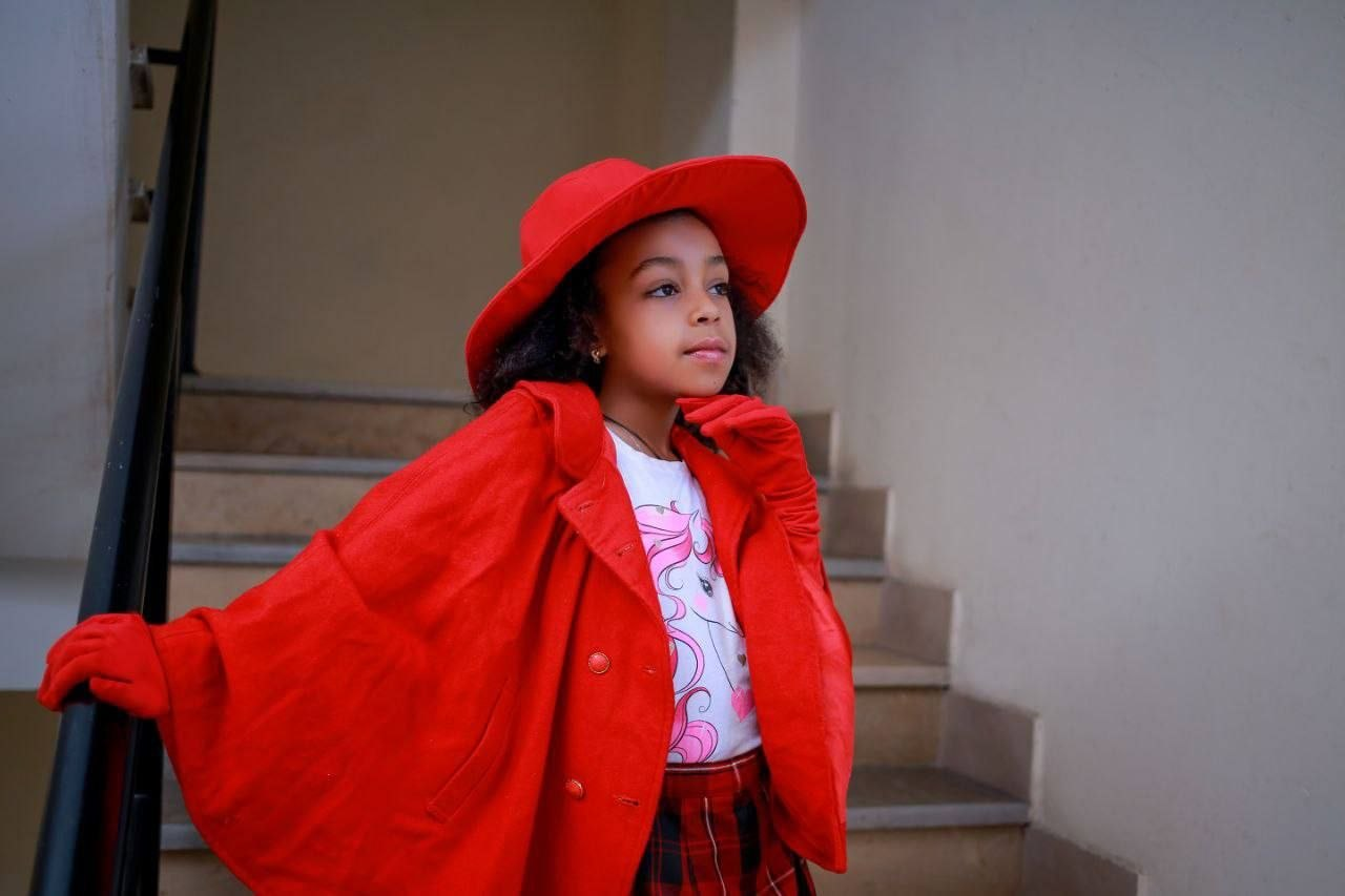 Child model wearing a bright red fashion look