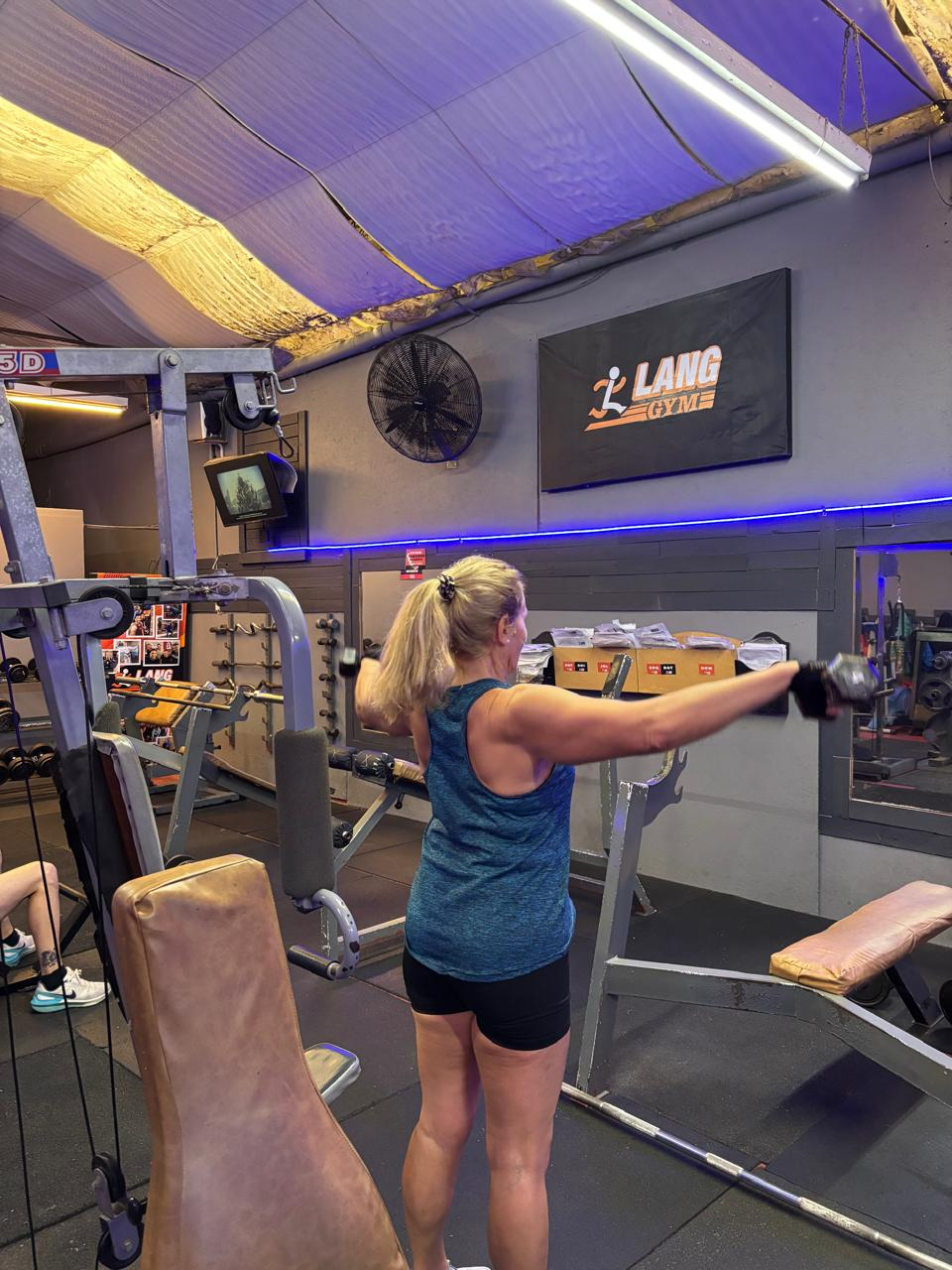 Mujer entrenando en máquina con iluminación LED