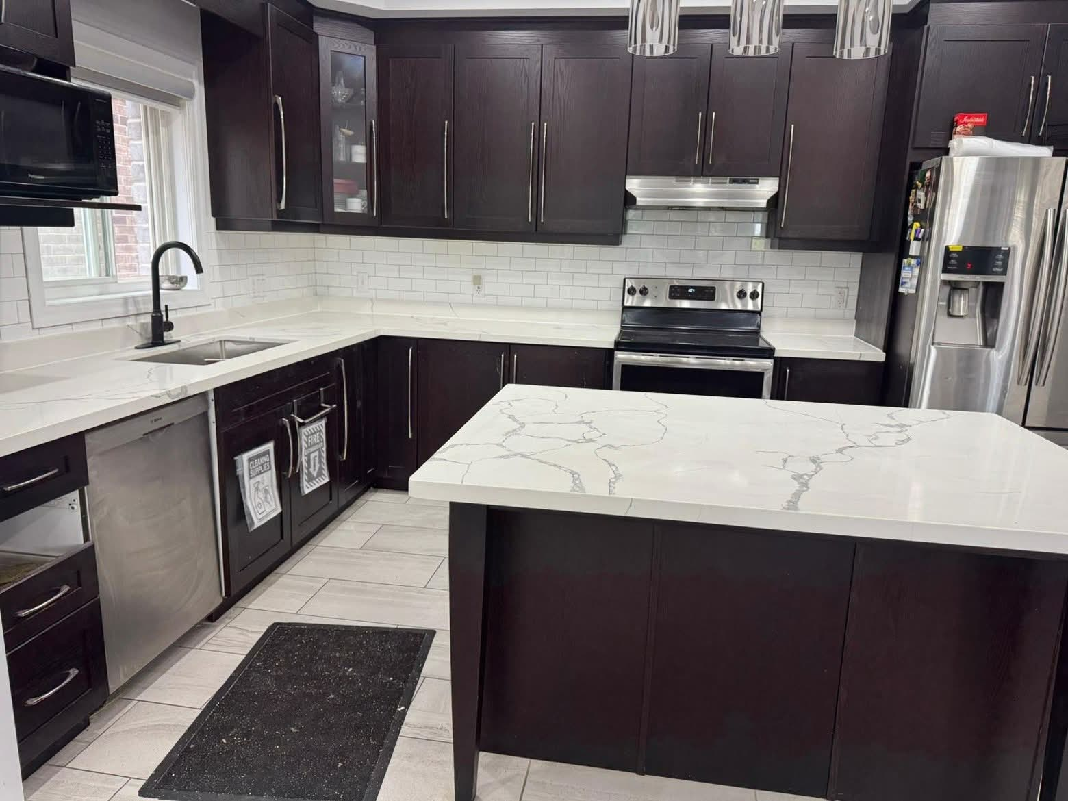 Dark cabinet kitchen with white quartz island