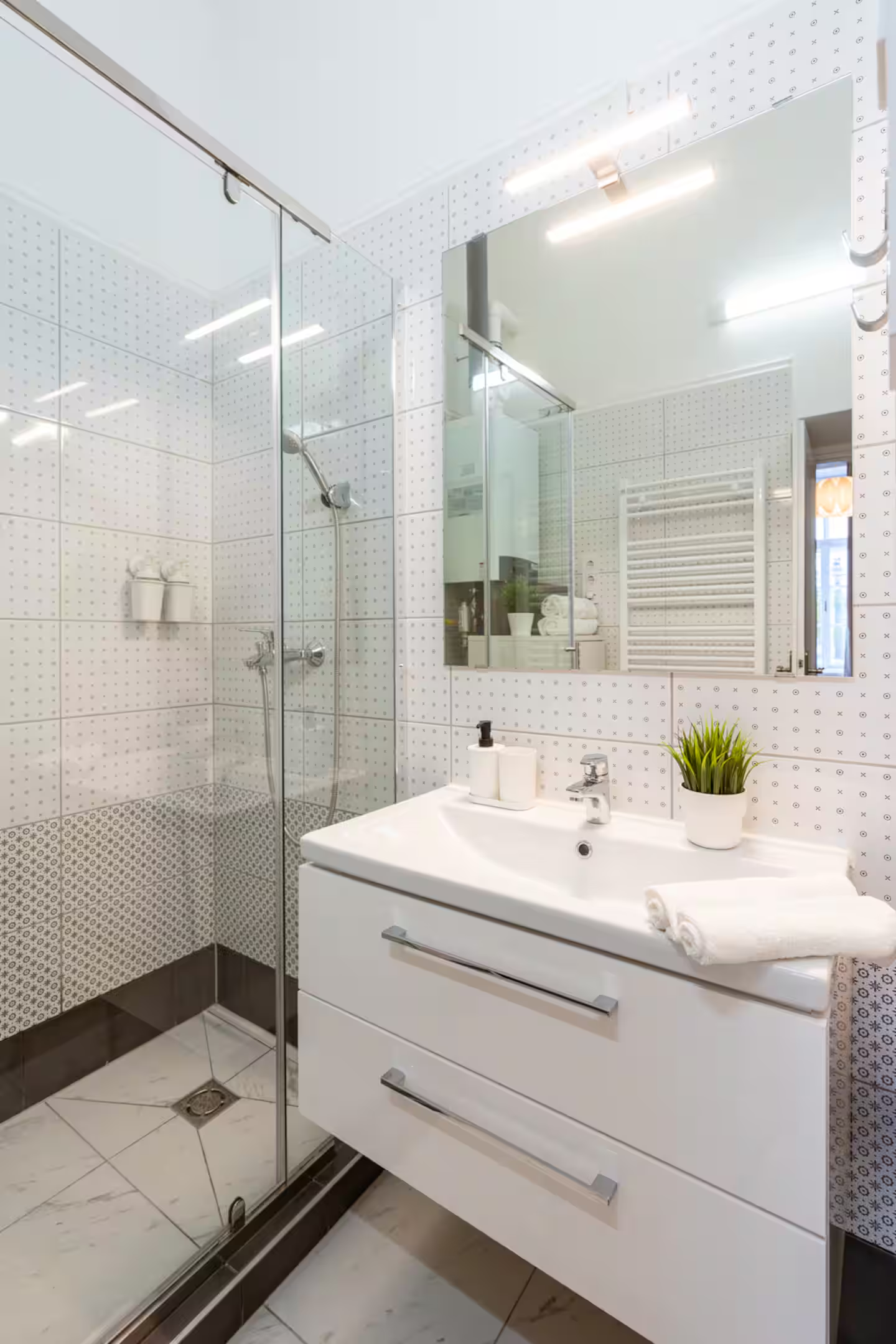 Modern white bathroom with glass shower enclosure and vanity