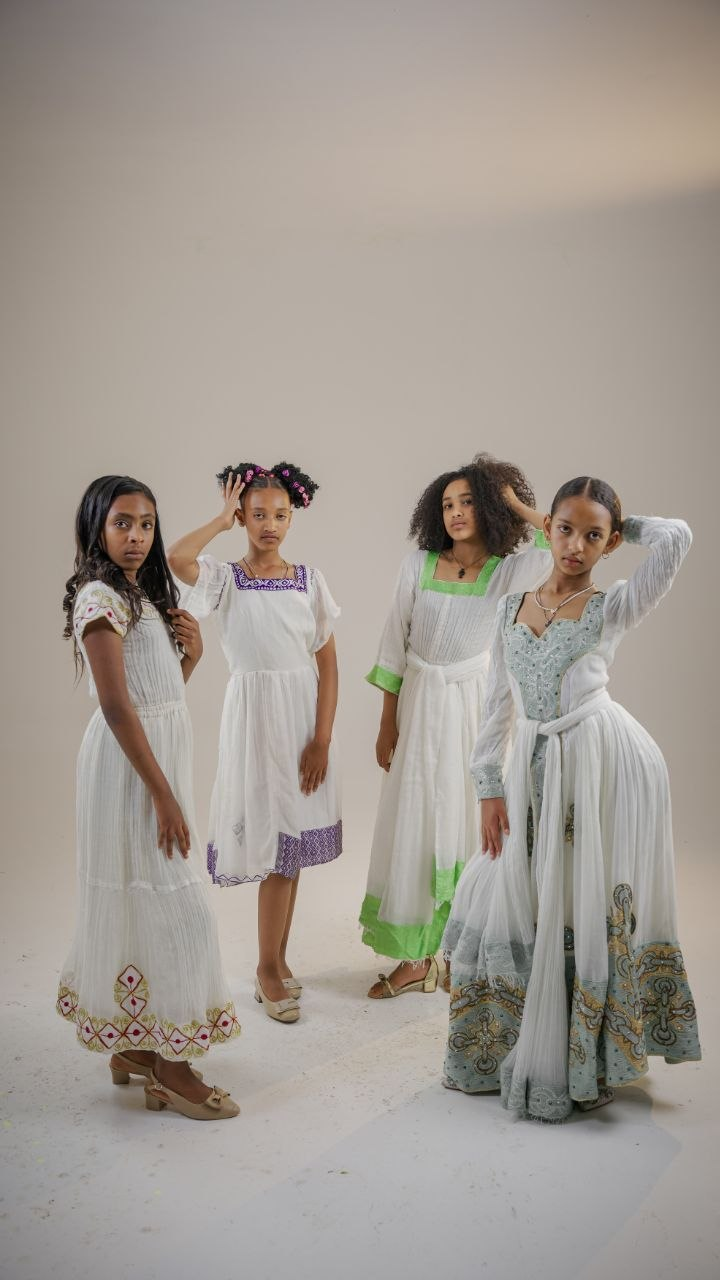 Four young models in flowing white dresses
