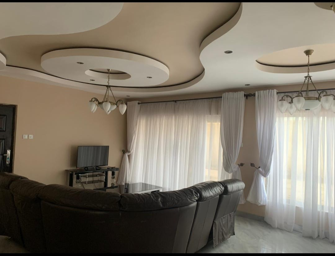 Living room with ornate curved plasterboard ceiling and chandeliers