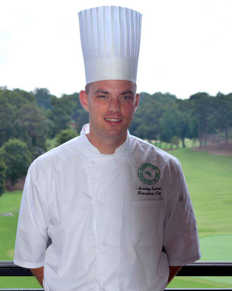 A younger Jeremy Leinen in a tall chef's toque overlooking a golf course