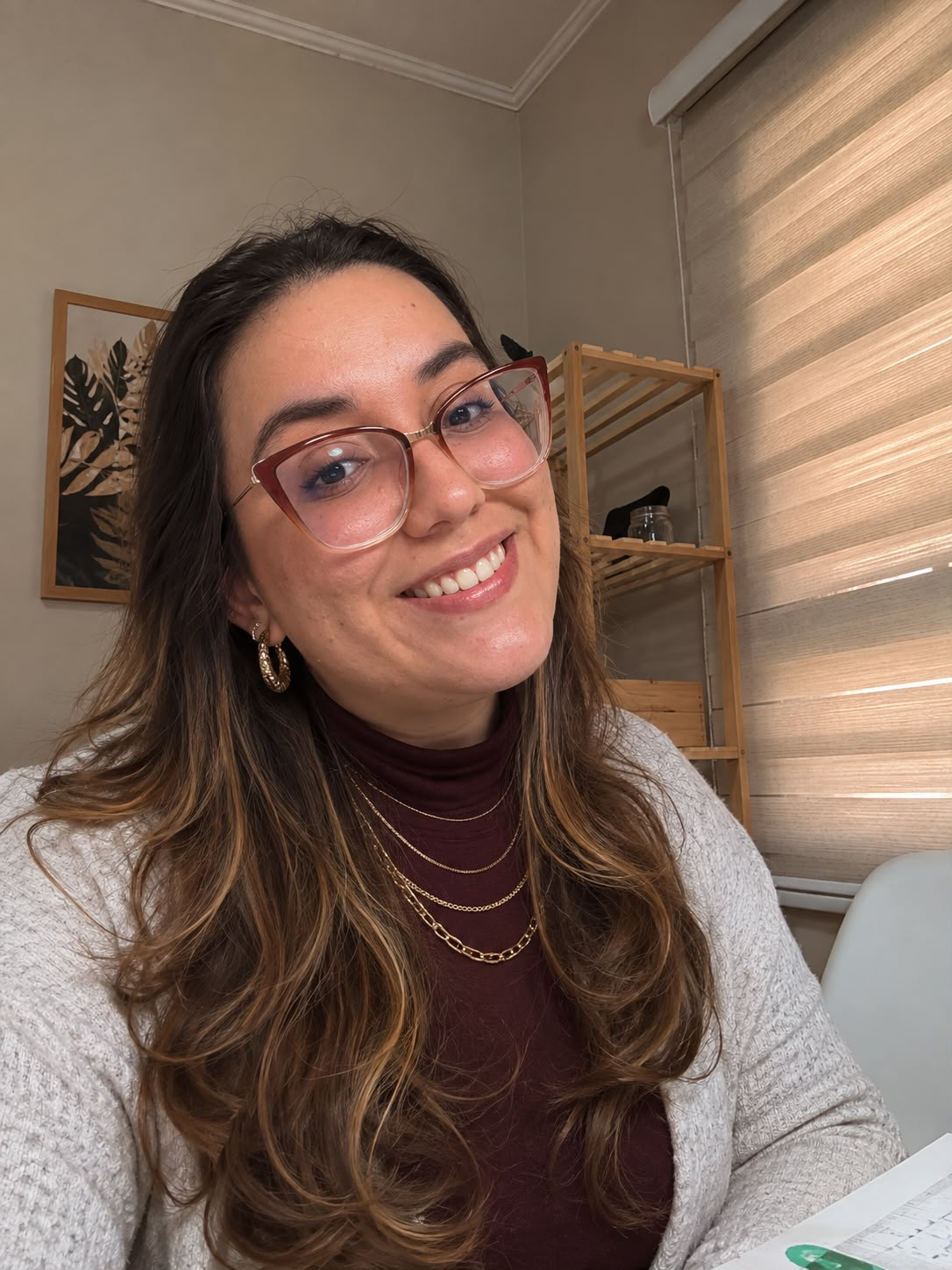 Gabriela Lima sorrindo, com óculos e cardigan claro