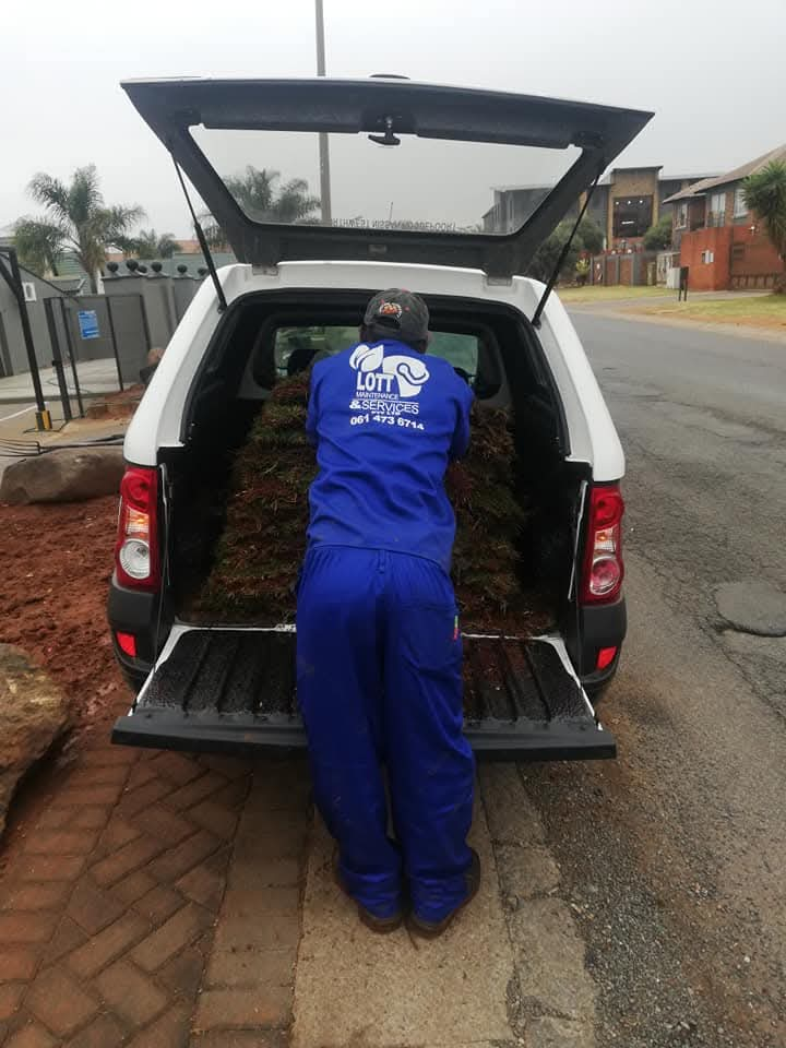 Lott Maintenance team member in branded uniform loading garden waste