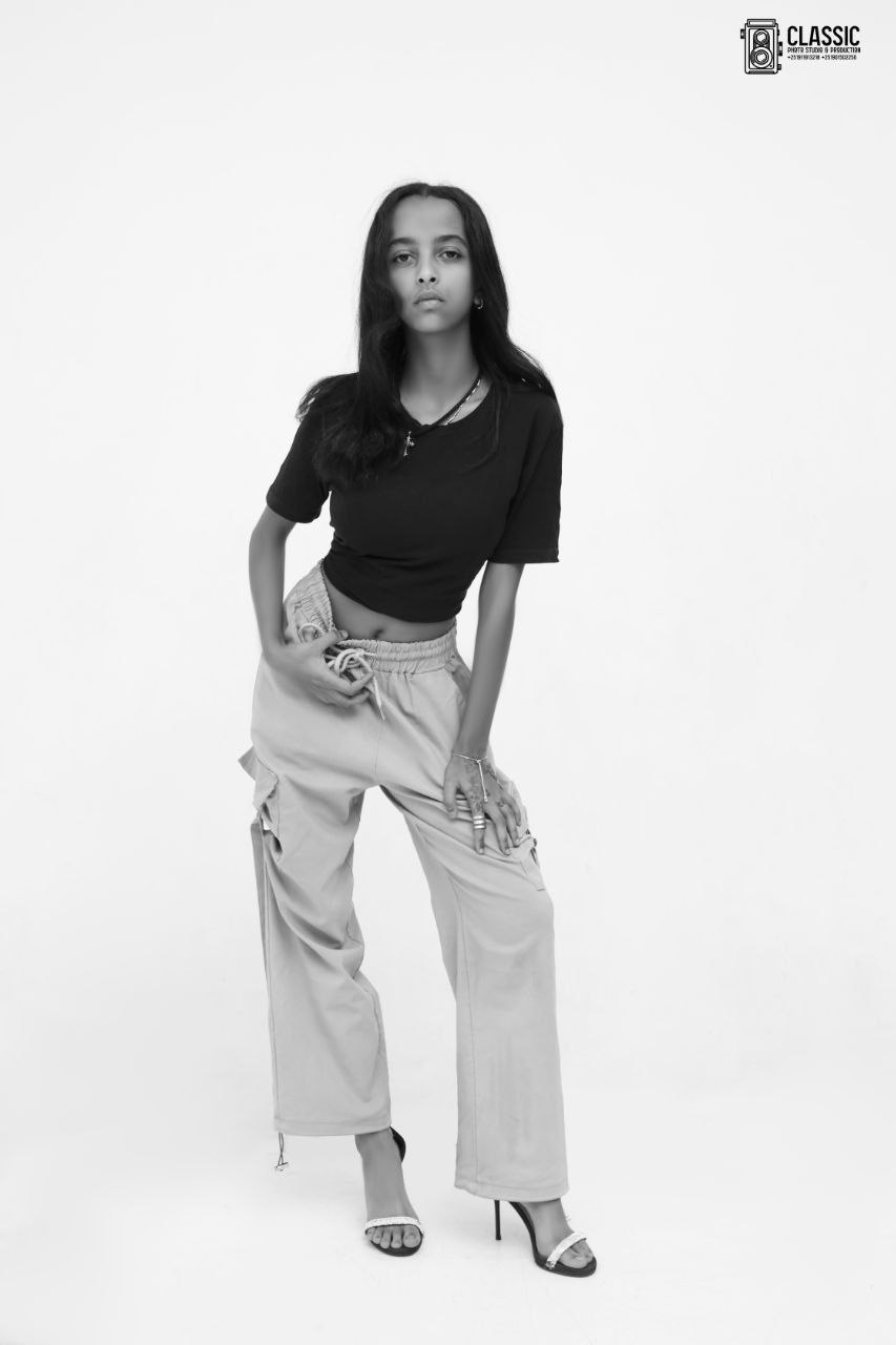 Model in a black top and light trousers
