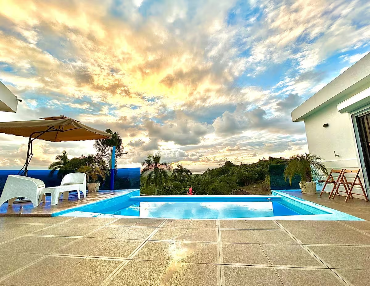 Vista espectacular de la piscina infinity durante un atardecer dorado con cielo dramático