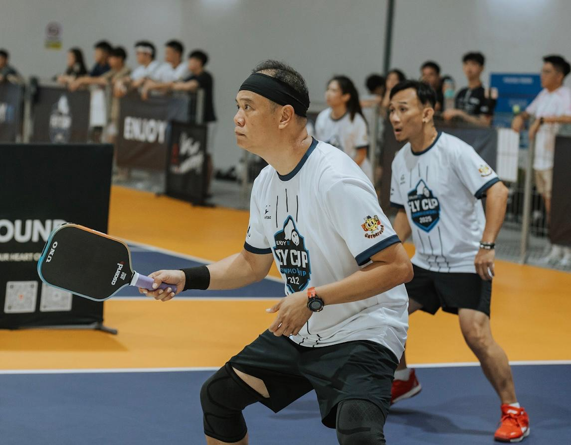 Player lunging with paddle during intense indoor pickleball match
