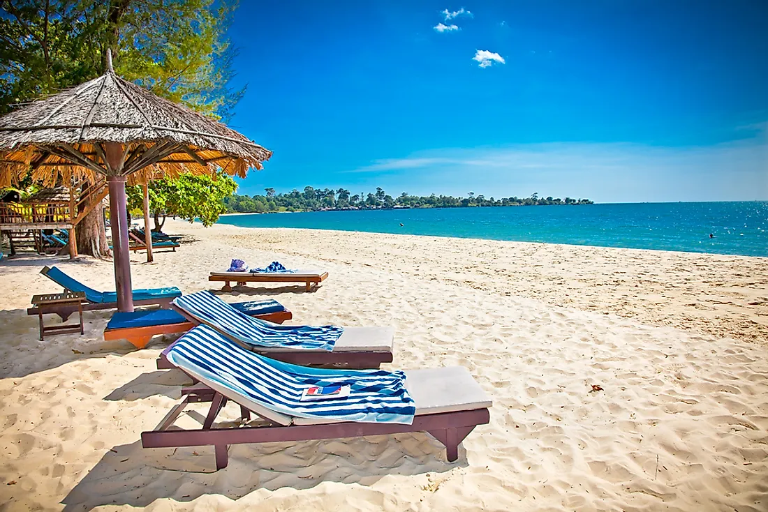 Luxury beach vacation with lounge chairs under a thatched umbrella