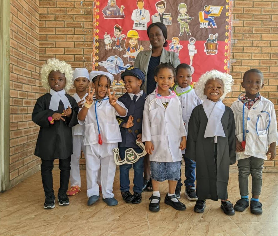 Pupils dressed as different professionals with their teacher on Career Day