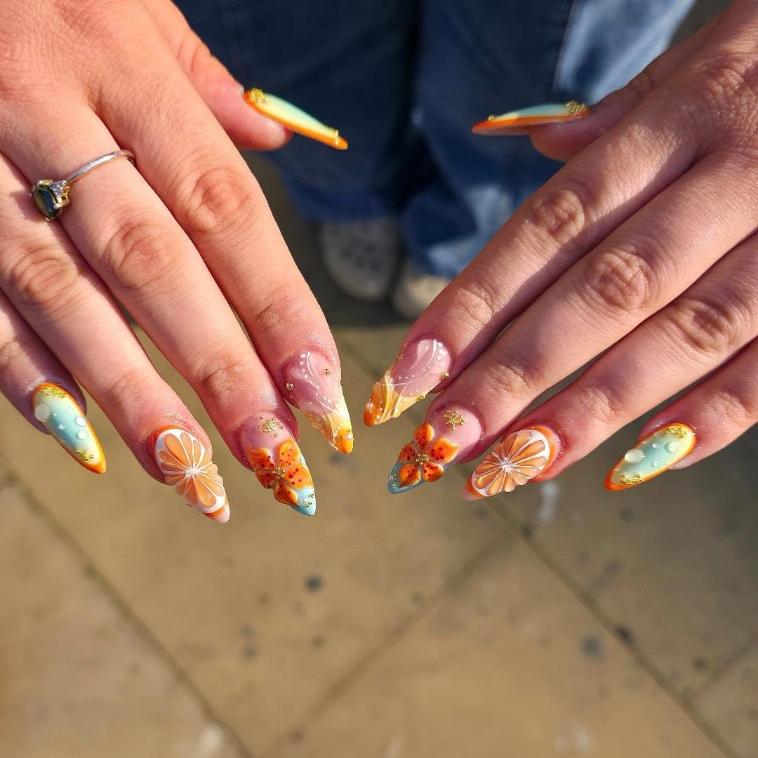 Orange and coral sunset themed nail art with flowers