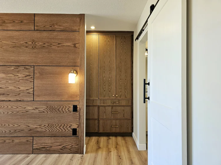 Primary suite with wood wall and barn door