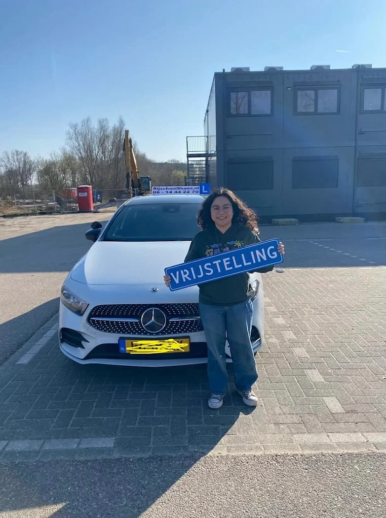 Geslaagde leerling naast de lesauto van Rijschool Shami