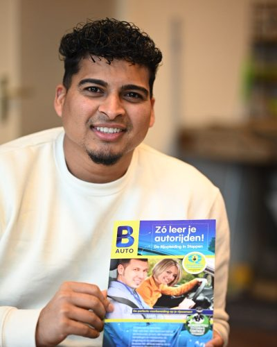 Airesh Badaltjawdharie — rijinstructeur DriveSupport Tilburg, houdt RIS theorieboek vast