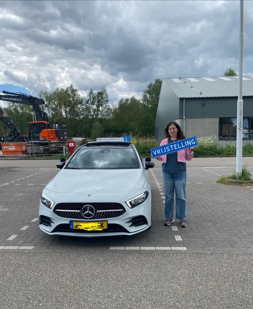 Geslaagde leerling met vrijstelling bord bij Rijschool Shami
