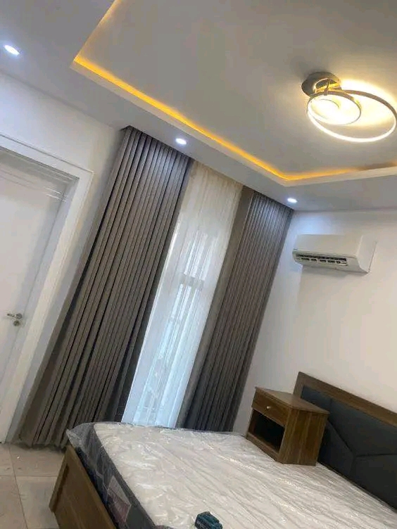 Bedroom with gold LED tray ceiling and grey curtains