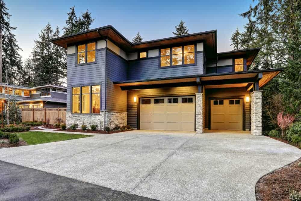 Modern luxury home with illuminated windows at dusk