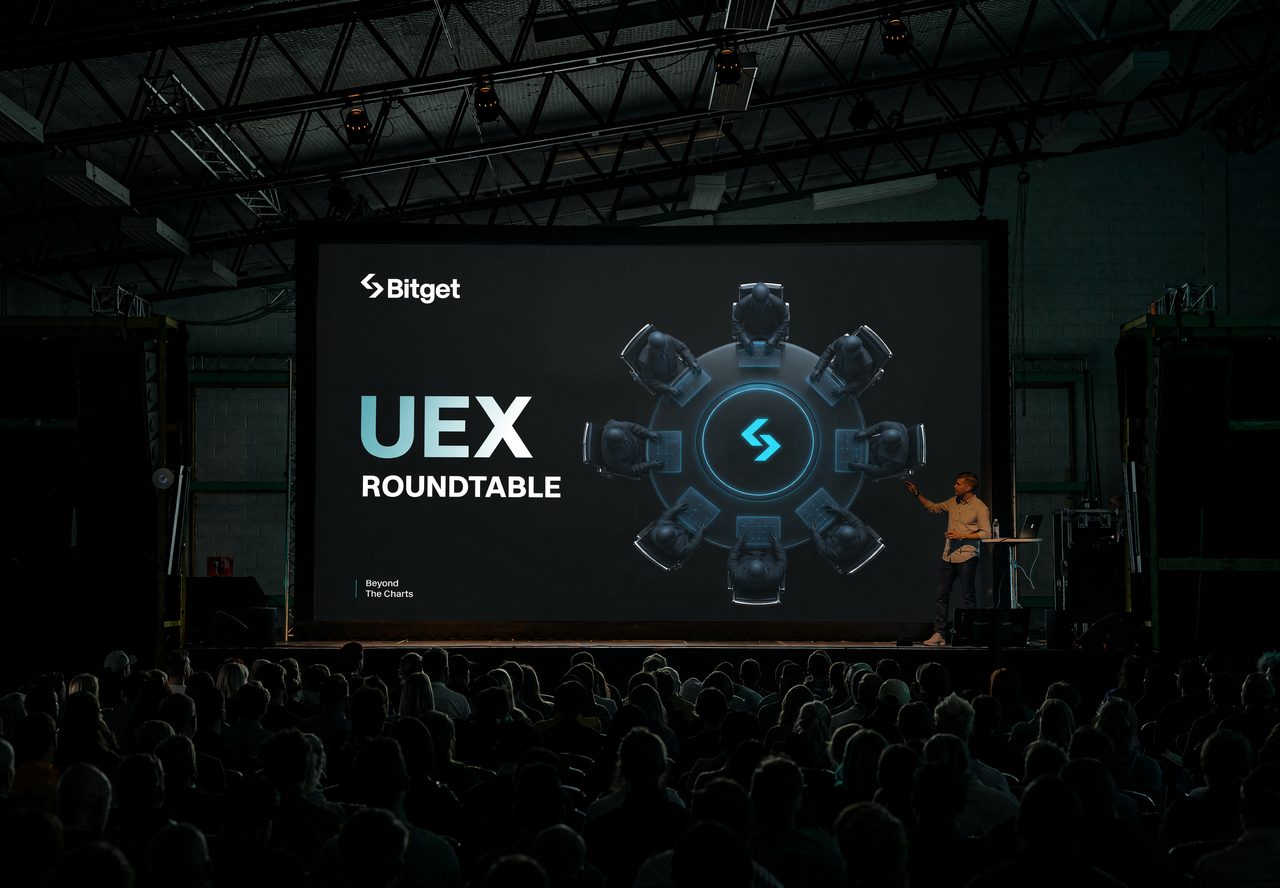 Bitget UEX Roundtable — presenter on stage at warehouse event space with audience