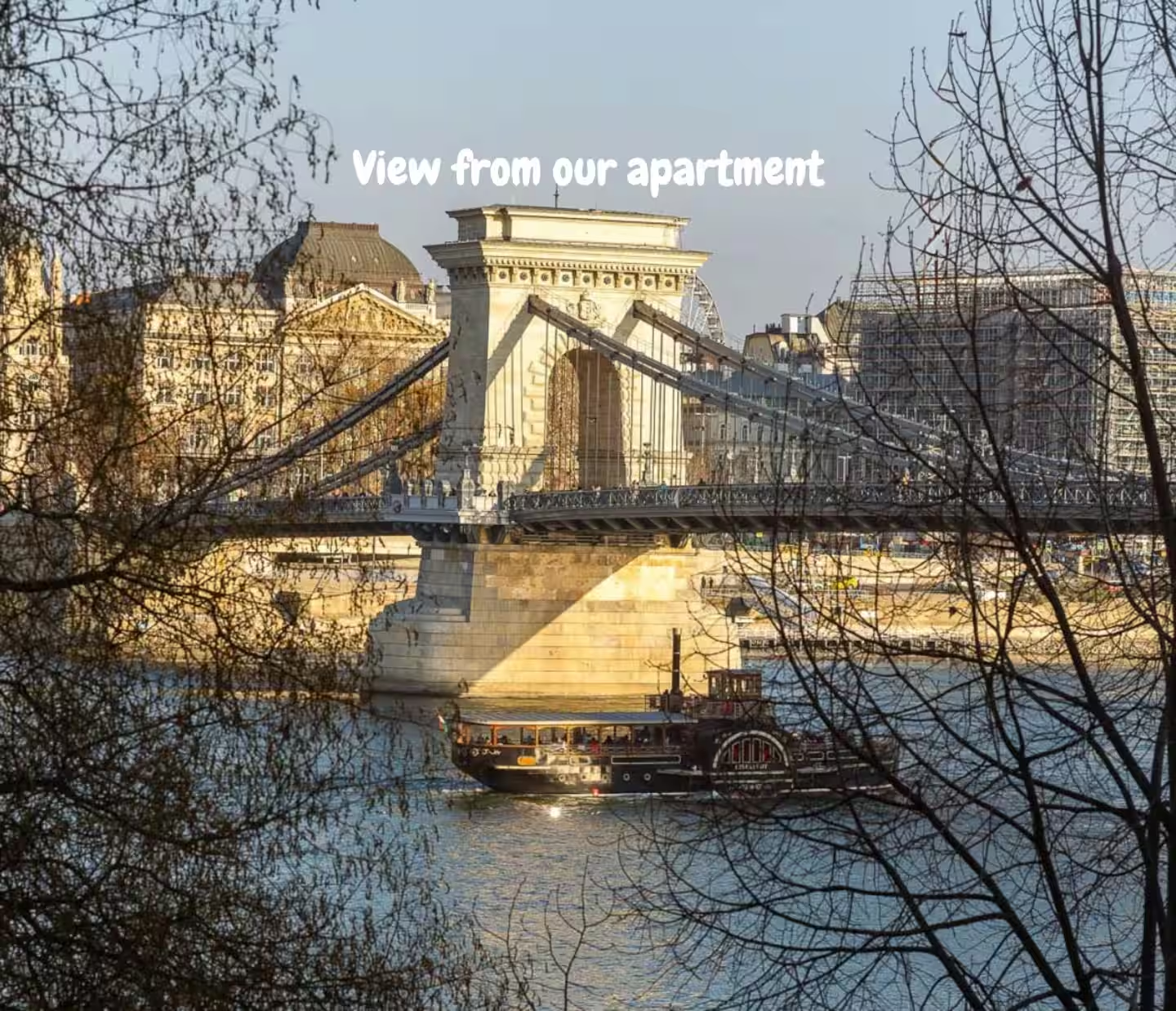 View of Chain Bridge from the apartment with a boat passing on the Danube