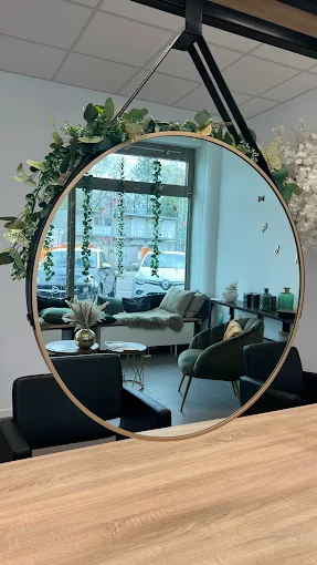 Runder Hängespiegel mit Goldrahmen und Dekopflanzen im Valessa Munich Salon