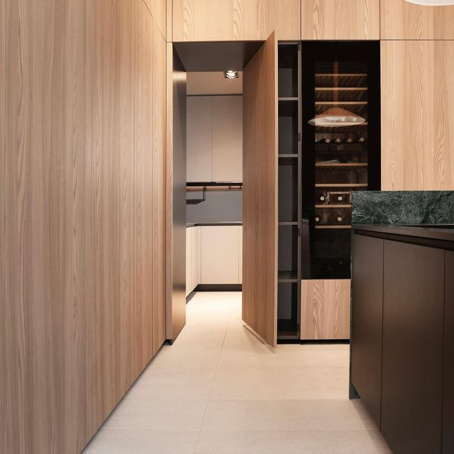 Luxury custom kitchen with light wood cabinetry, butler's pantry with wine fridge, and green marble island