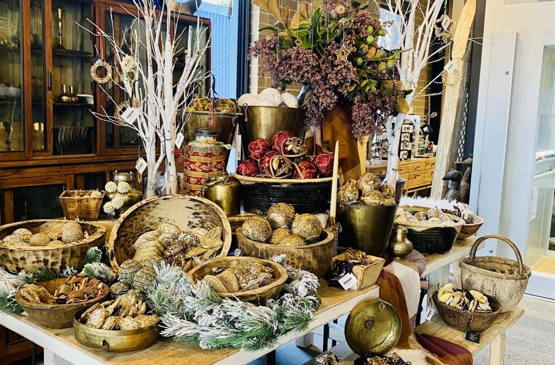 Luxurious interior display with gold brass vessels, woven baskets, dried botanicals, and curated decorative objects — interior styling by Jayne Michelle Interiors
