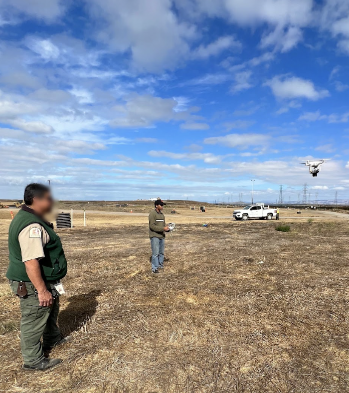 Drone dispersal test in a field with a pilot and observer