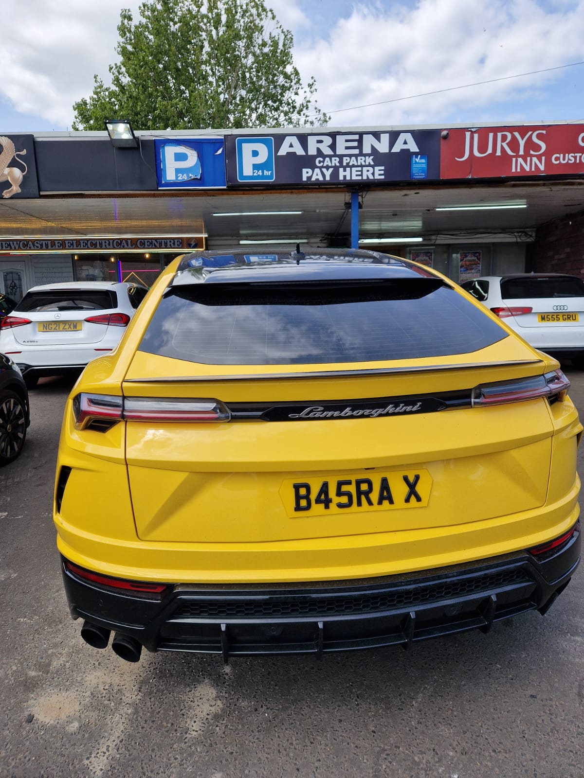 Yellow Lamborghini Urus rear at Arena car park
