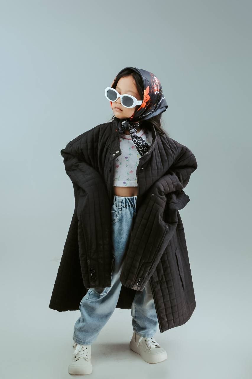 Young model wearing sunglasses and a quilted coat