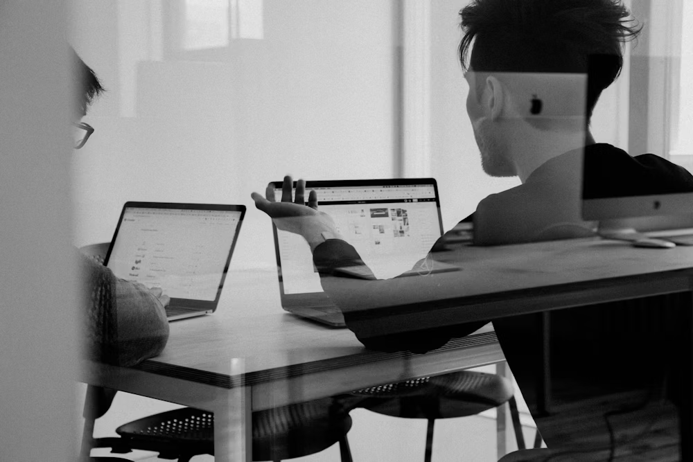 Creative team collaborating around laptops in a studio
