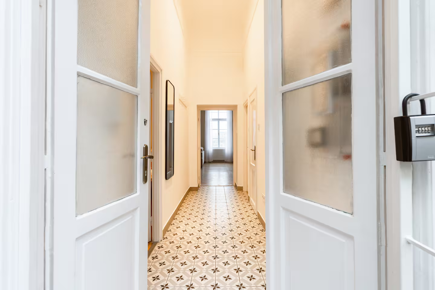 Charming hallway with patterned tile floor and white doors
