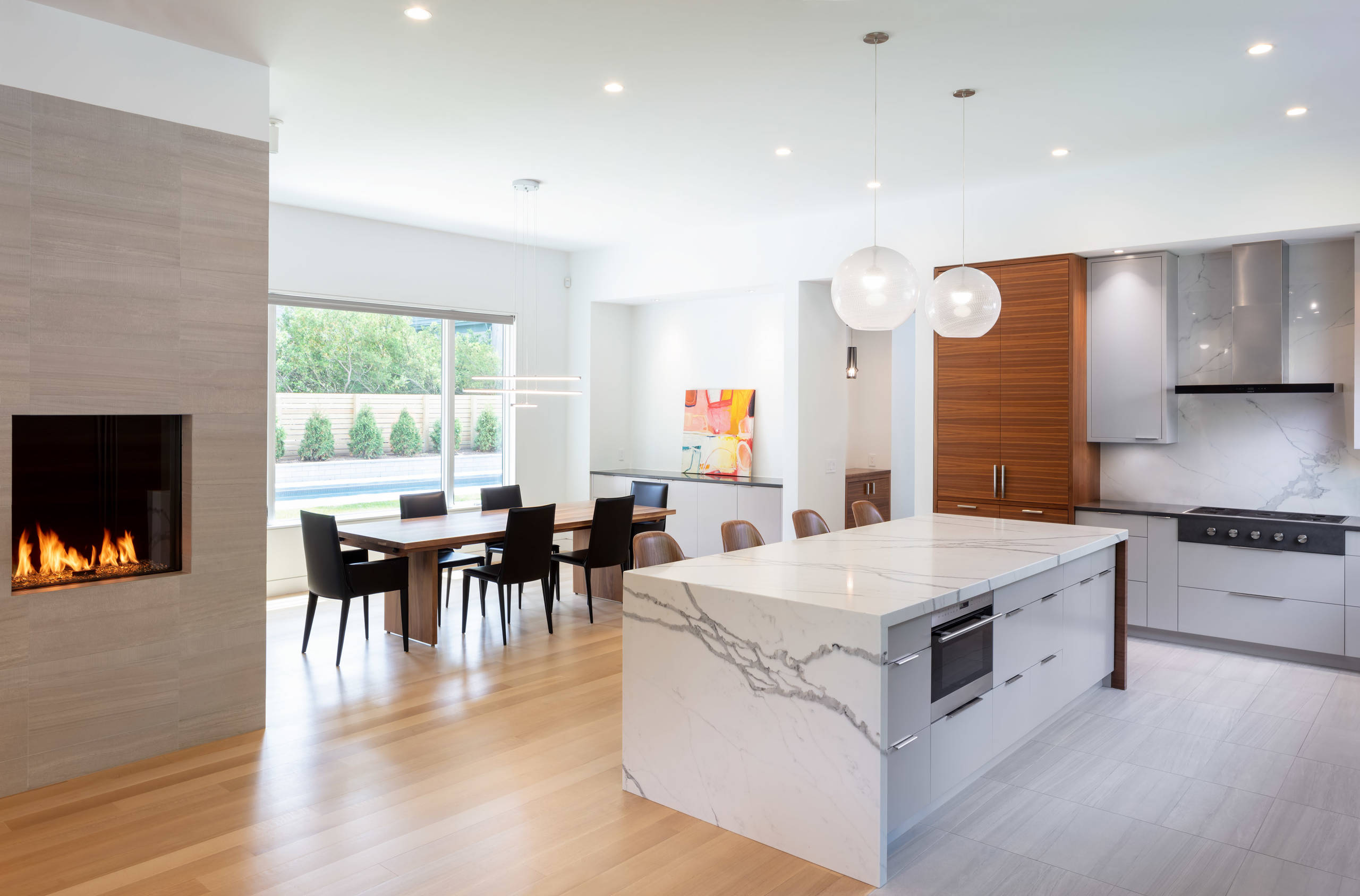 Bright open-concept kitchen with marble waterfall island and fireplace — Rockville