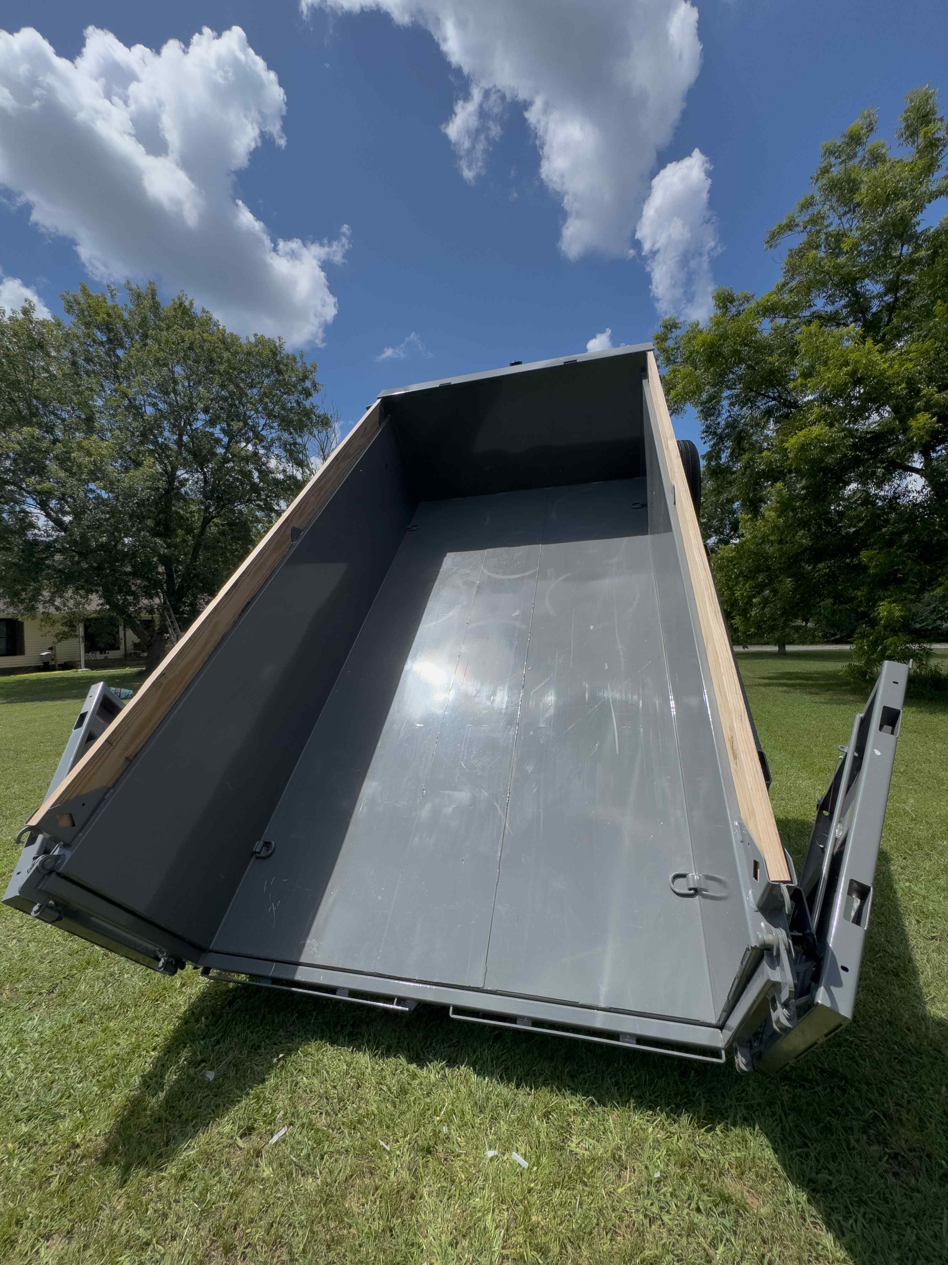 Dumpster trailer bed fully raised showing smooth steel interior floor