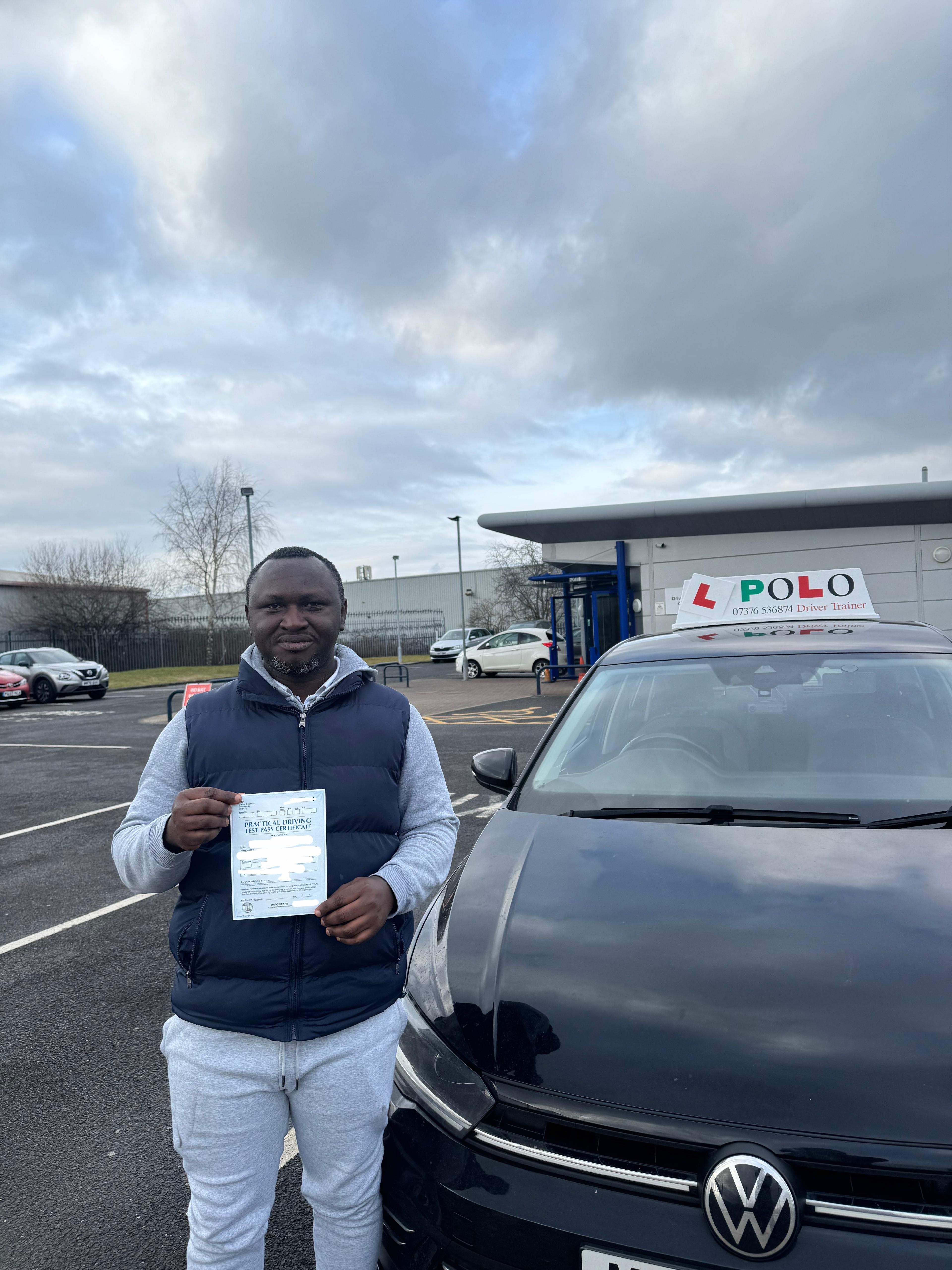 Student holding their driving test pass certificate outside the test centre