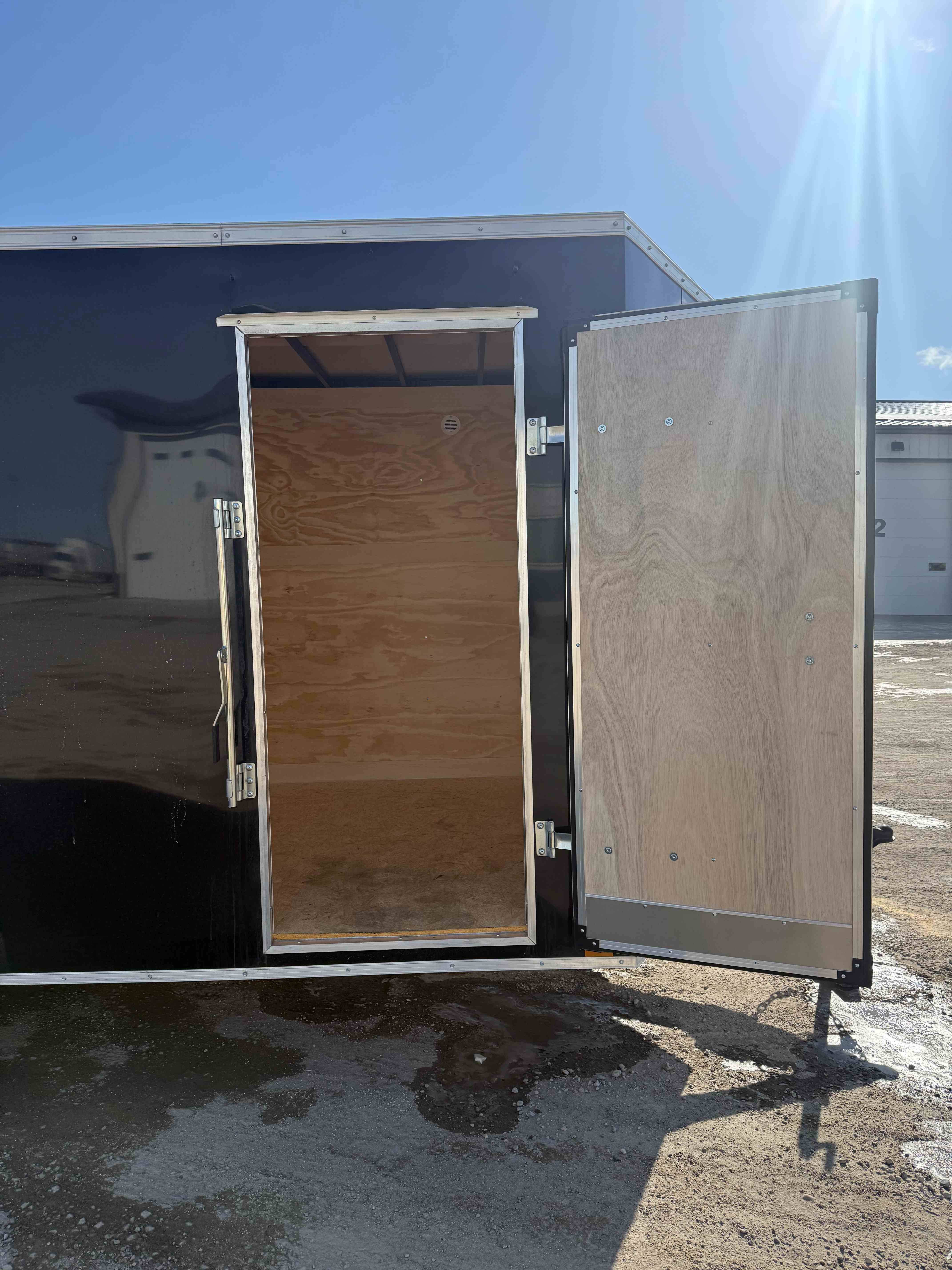 7x16 Cross enclosed trailer - rear doors open showing plywood interior