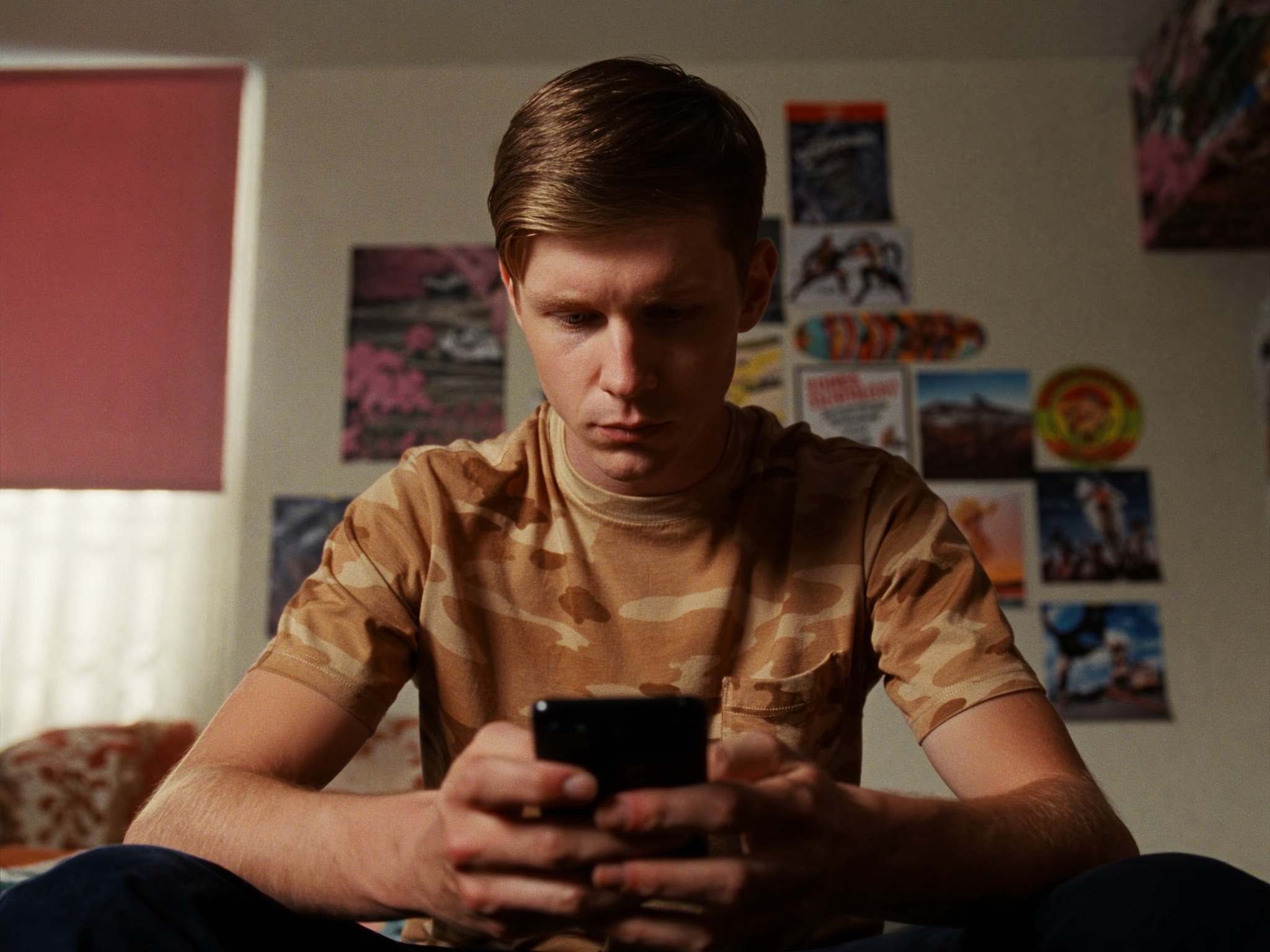 Young man looking at phone in his bedroom