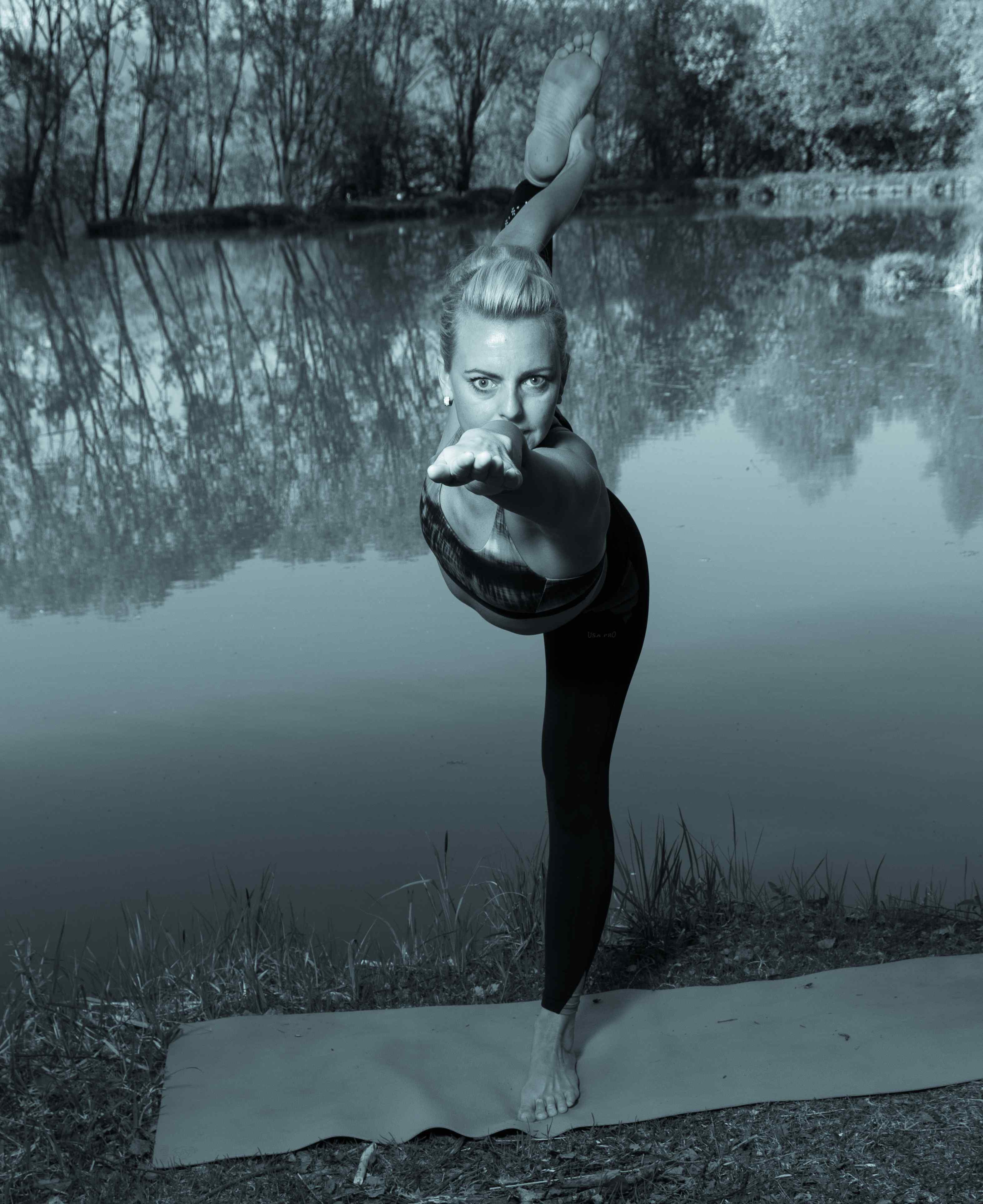 Daniela in einem Stehenden Standbein-Balance an einem Teich