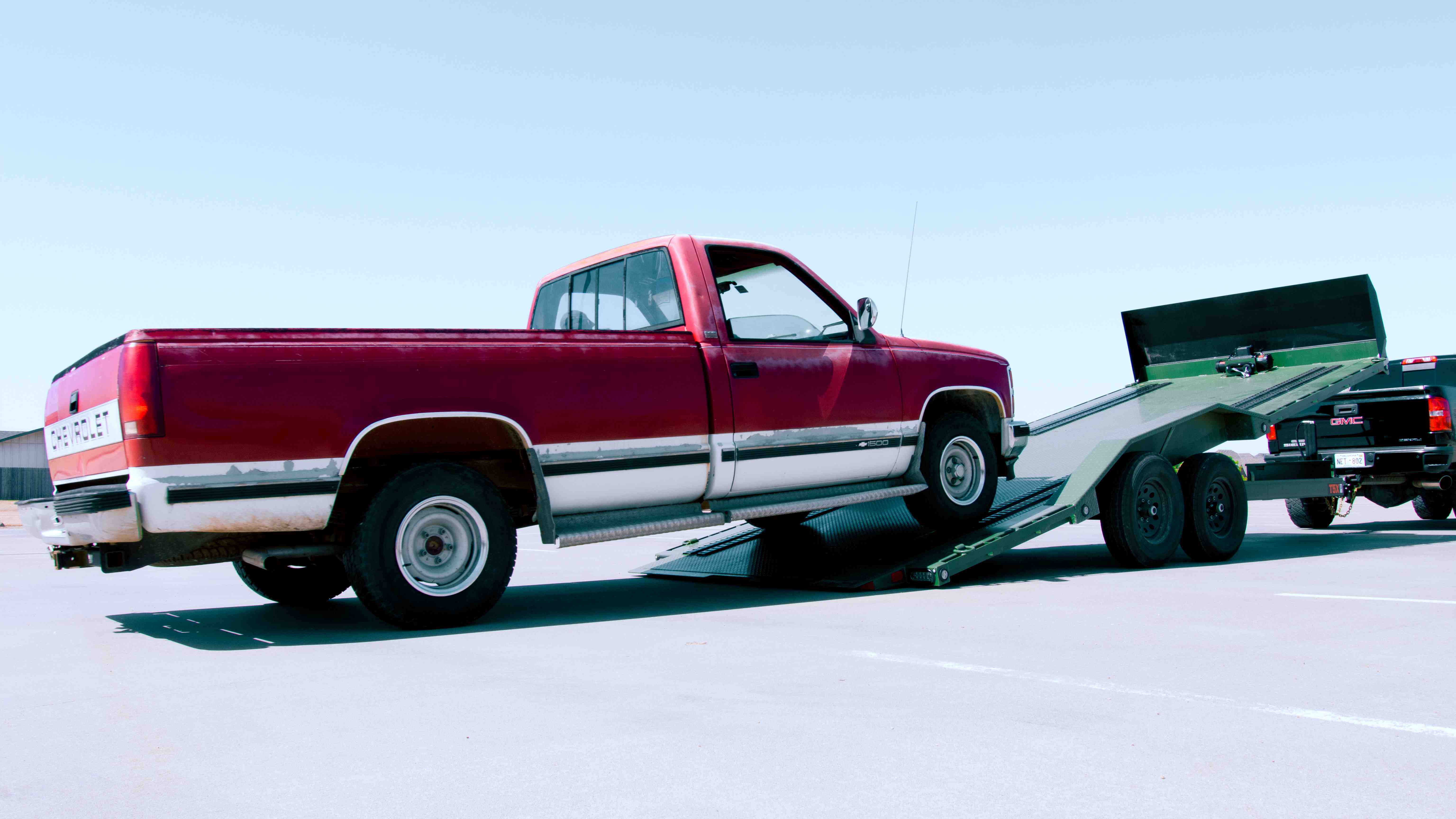 Red Chevrolet truck being loaded onto the Maxx-D T5X tilt car hauler