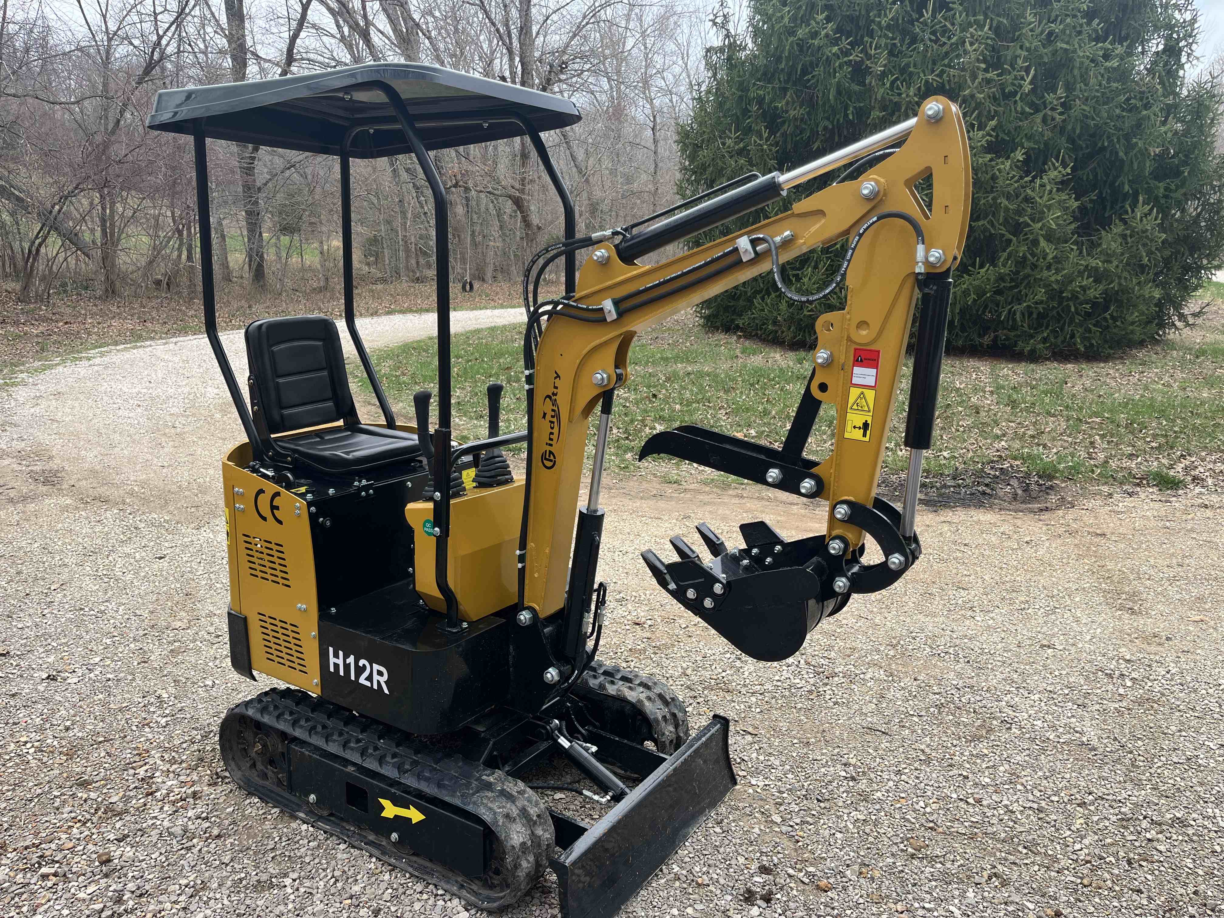 Findustry H12R mini excavator with canopy and hydraulic arm on gravel driveway
