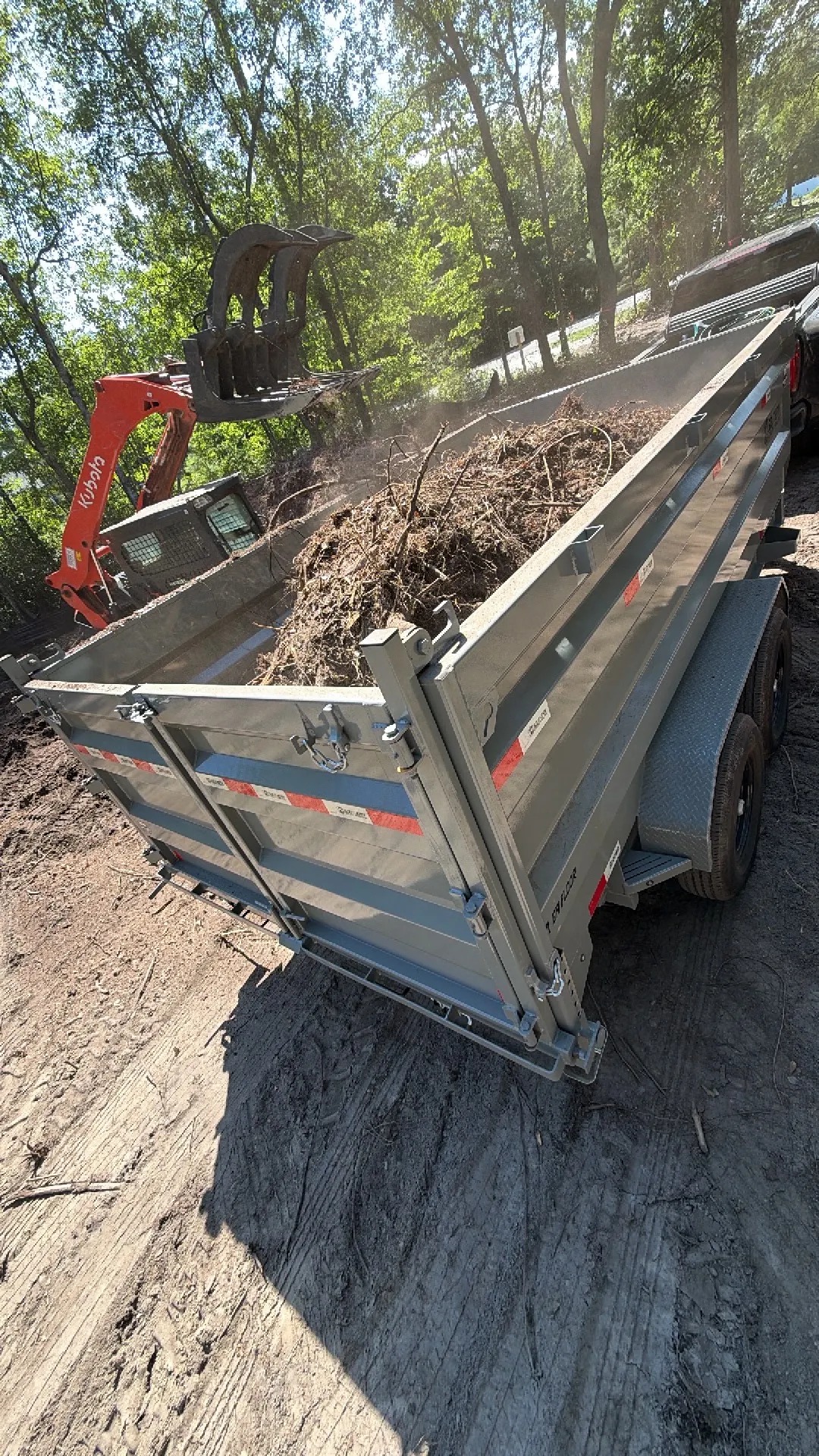 Dump trailer loaded with brush and debris at a job site