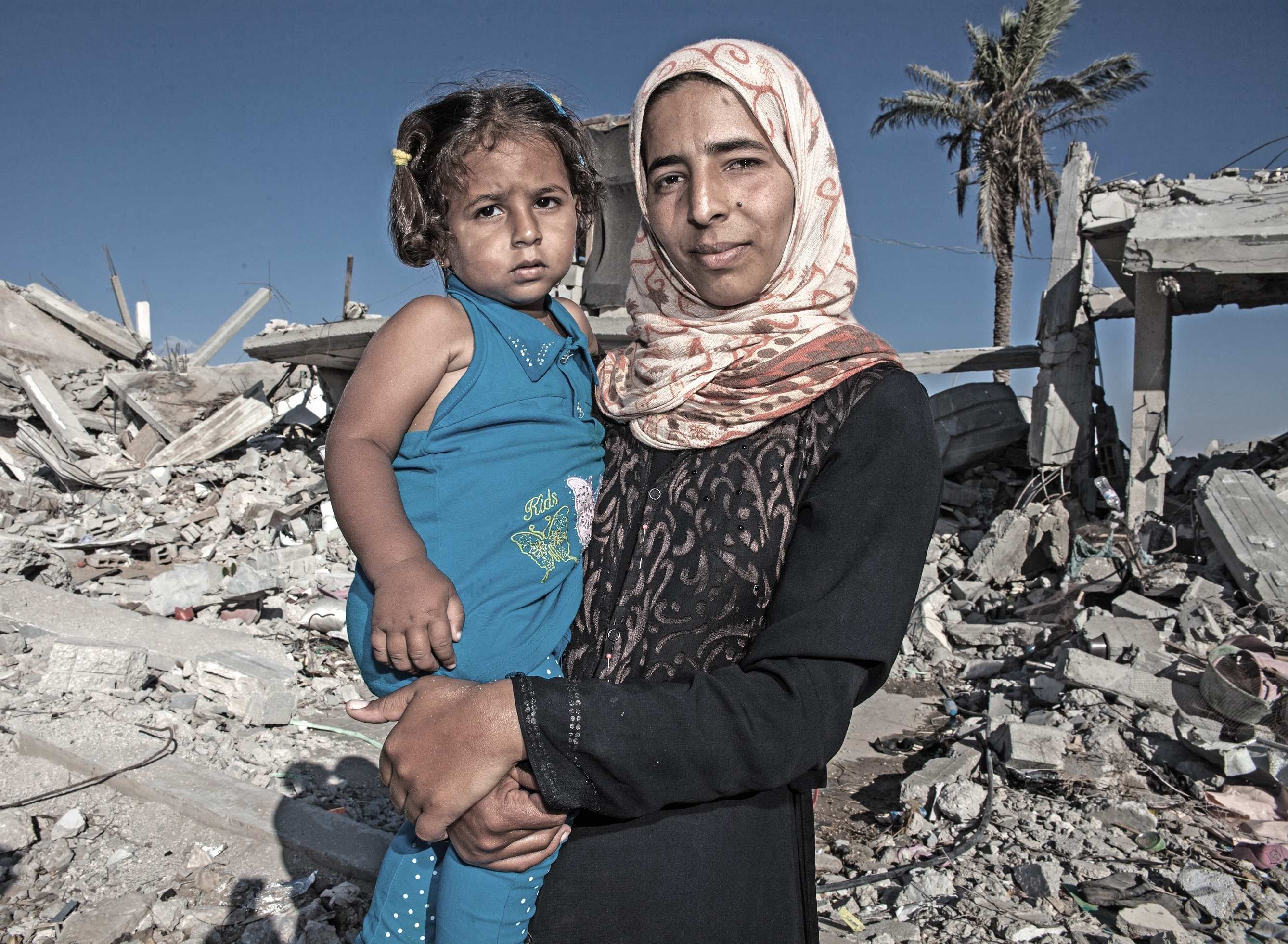 Mor og barn i Gaza foran ødelagt hjem