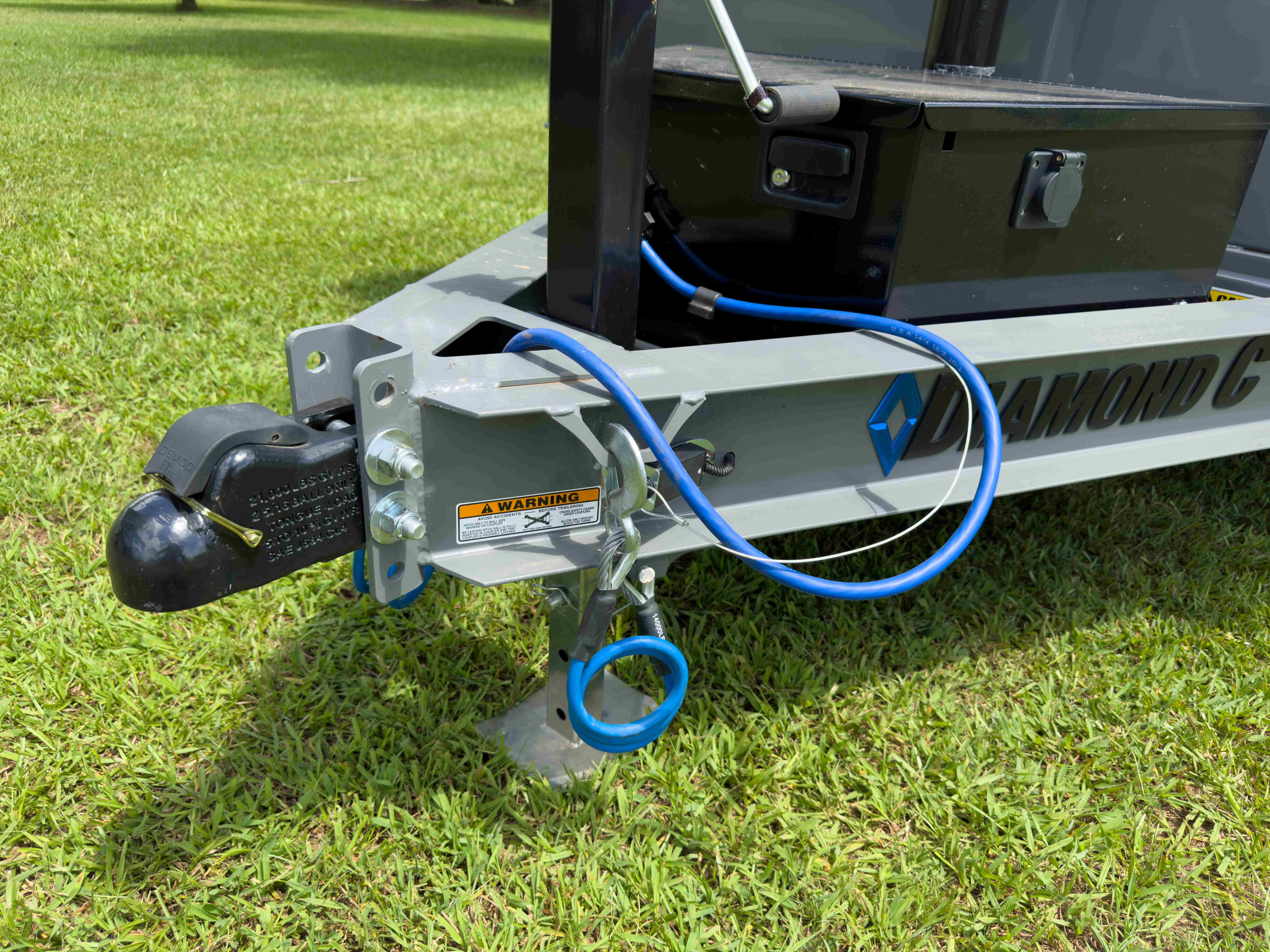 Diamond C dumpster trailer coupler, jack stand, and breakaway cable close-up