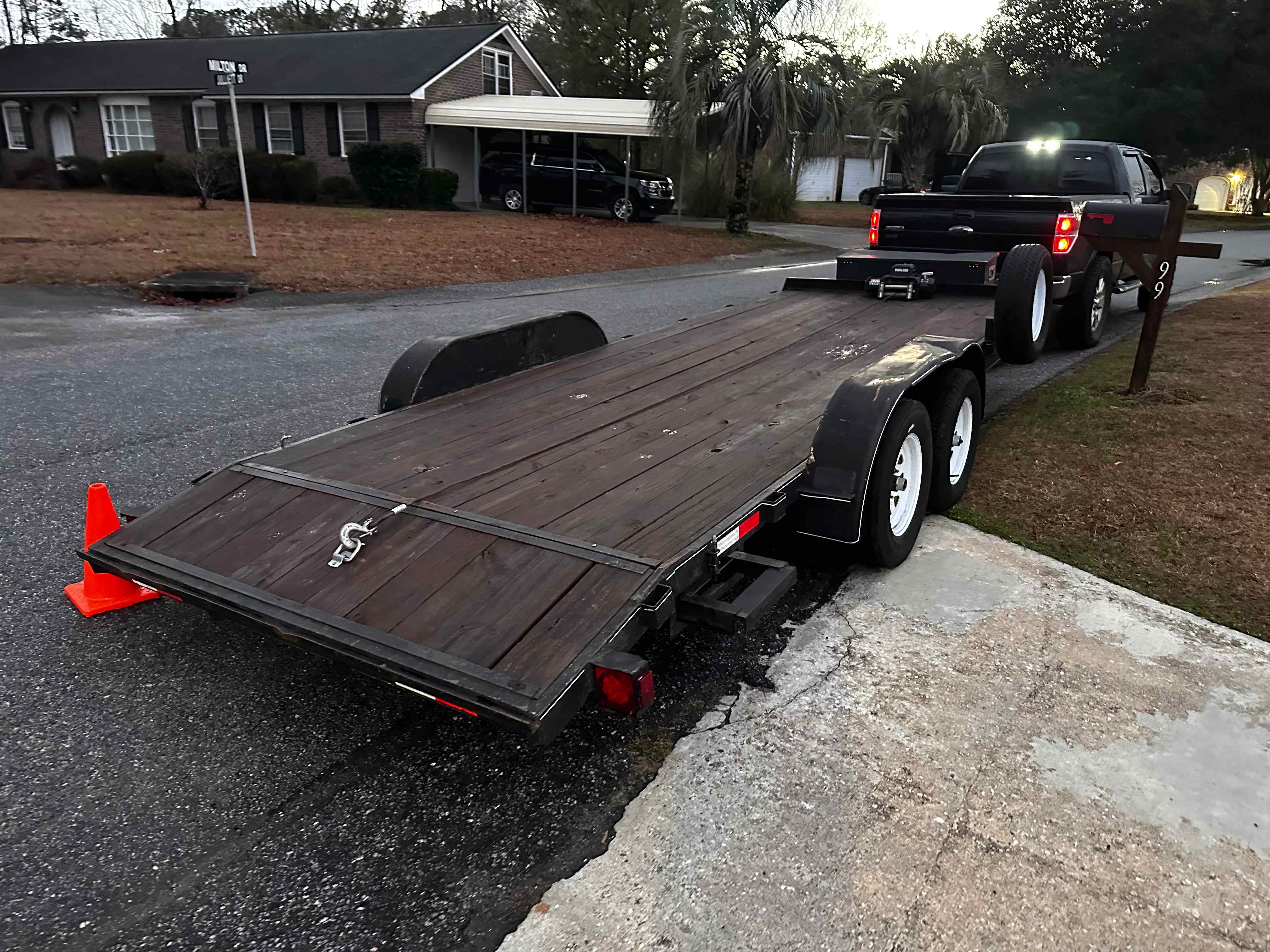 Empty wooden deck car hauler trailer hitched to a truck